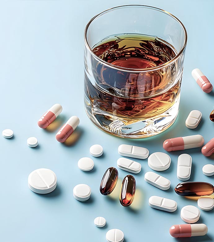 Tabletten und ein Glas Alkohol als Symbol für Suchterkrankung
